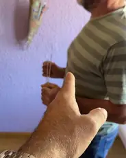 Alumno practicando con varillas en una vivienda