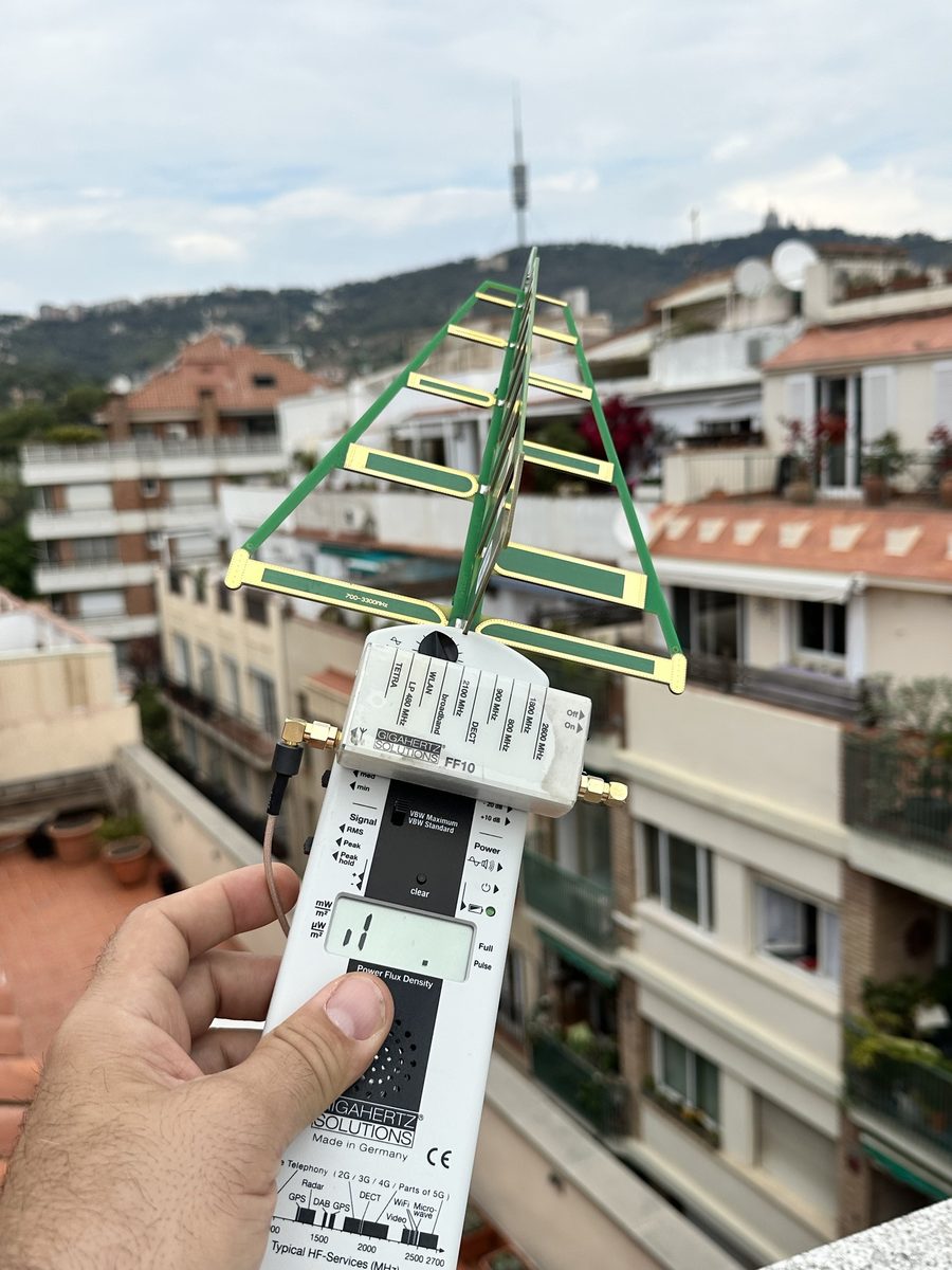 Medidor de alta frecuencia con antena logarítmica en una azotea de Barcelona, con la Torre de Collserola al fondo